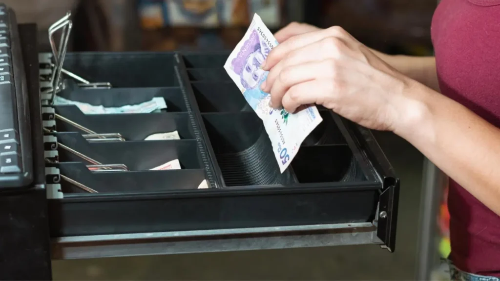 mujer haciendo arqueo de caja registradora en Colombia