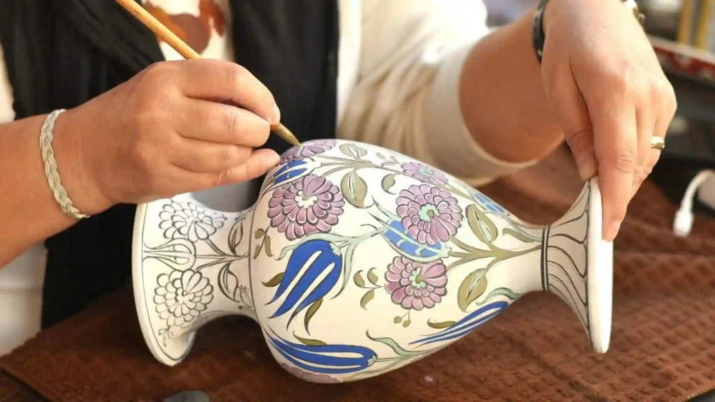 ceramista pintando una pieza, en representación de la economía naranja