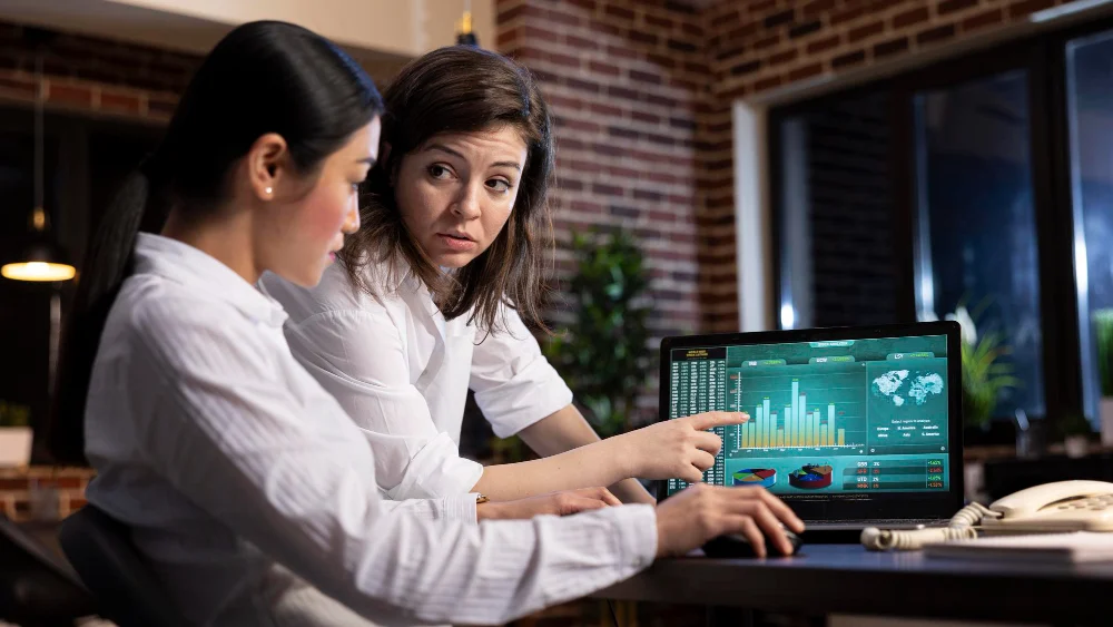 IA en la labor contable. Mujeres revisando gráfico en la computadora